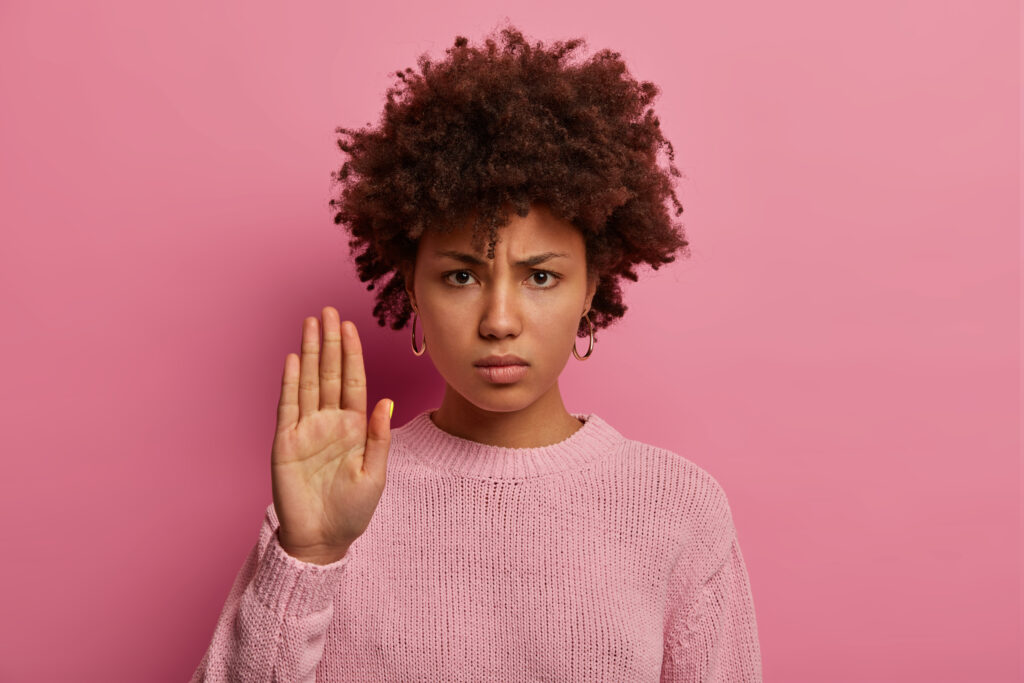 mujer enojada piel oscura peinado afro extiende palma